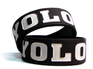 Two 1 inch ink injected wristbands with a personal message saying YOLO.