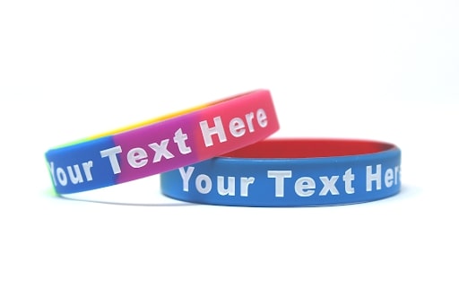Rainbow colored wristband with the message your text here.