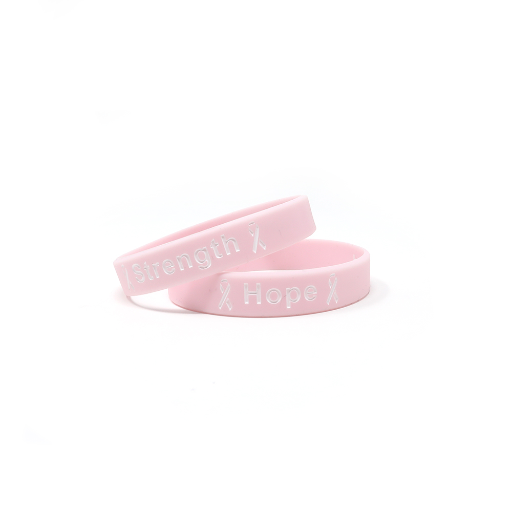 Ink injected wristbands that say strength and hope that represents breast cancer.