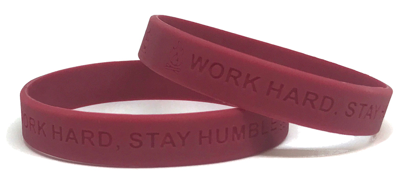 Two maroon debossed wristbands with personal messages.