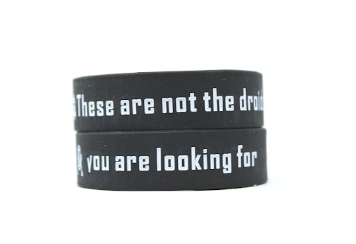 Two black wristbands stacked with the message these are not the droids you are looking for.